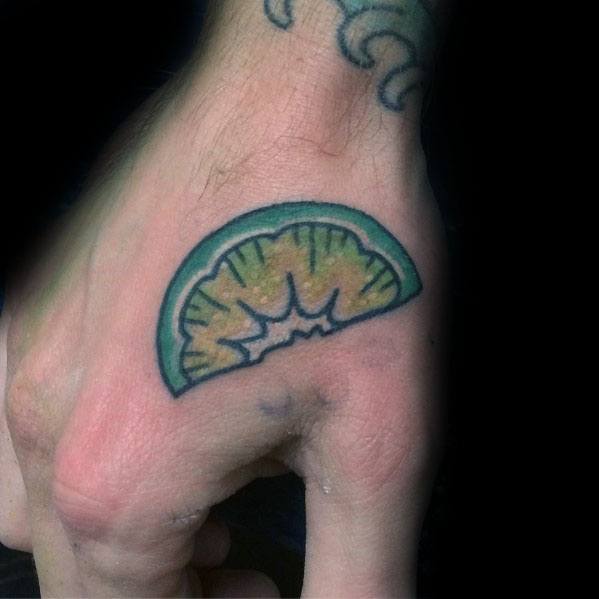 Bold lime wedge tattoo on the hand with vibrant green and yellow shading, featuring a simple yet striking citrus-inspired design.