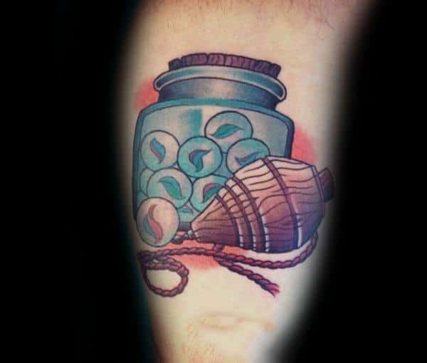 Colorful tattoo of a jar filled with marbles and a wooden spinning top, symbolizing nostalgia and childhood memories with vibrant shading.