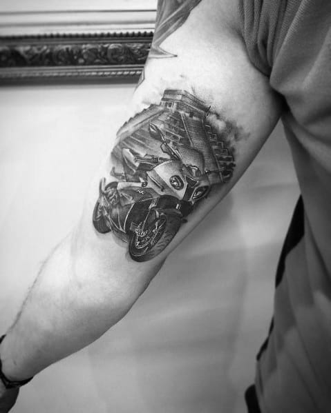 Realistic BMW S1000RR motorcycle tattoo on upper arm, featuring bold shading and motion effects for a dynamic, high-speed design.