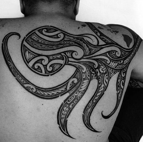 A large, intricate tribal tattoo design covering a man's back and upper arm
