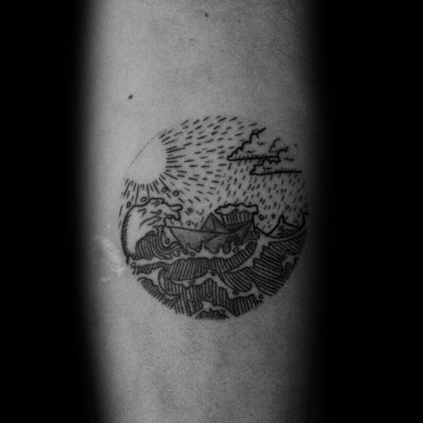 Small circular paper boat tattoo with stormy waves, sun, and rain, symbolizing life’s ups and downs and the journey through challenges.