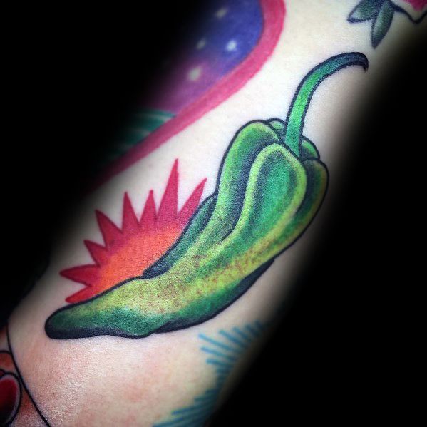 Realistic green chili pepper tattoo with bold shading and vibrant details, set against a colorful background for a dynamic look.