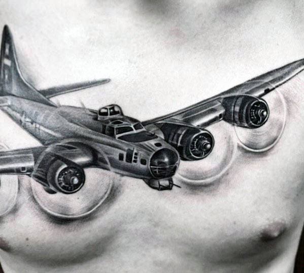 Realistic black and grey chest tattoo of a vintage four-engine bomber in flight, with detailed shading and motion effects on the propellers.