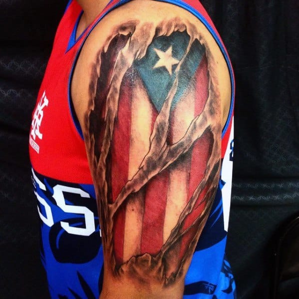 Puerto Rican flag tattoo with a realistic torn skin effect on the upper arm, revealing bold red, white, and blue colors with a striking star.
