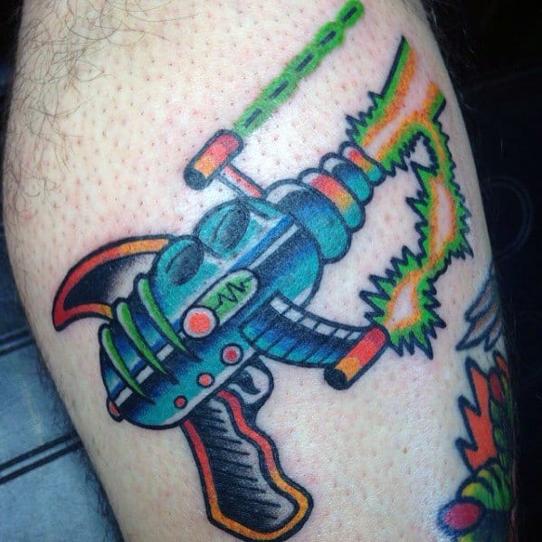 Bold and colorful ray gun tattoo with a retro sci-fi design, featuring bright neon accents and electric energy beams for a dynamic look.