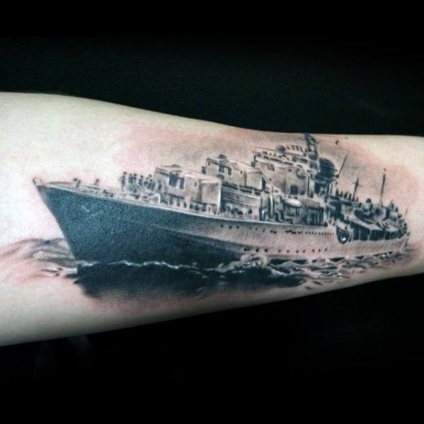 Battleship tattoo intricately detailed on a forearm against a dark background