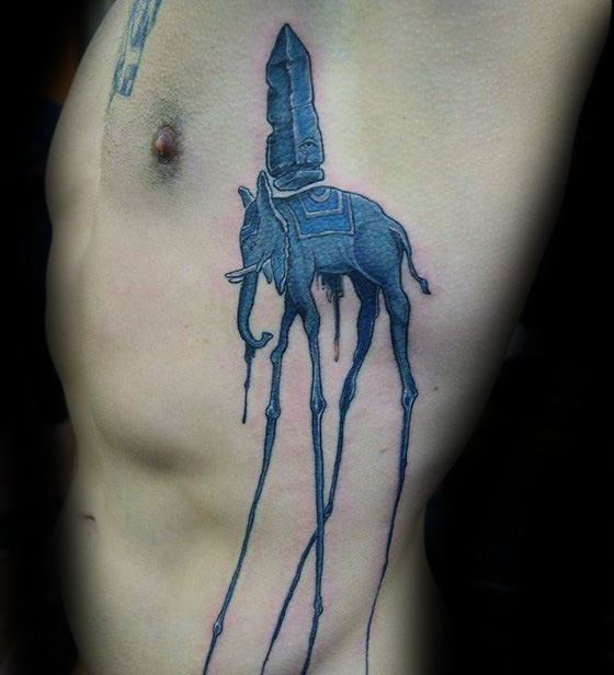 Blue Salvador Dali-inspired tattoo of a surreal elephant with spindly legs and an obelisk on its back, placed on the ribcage.