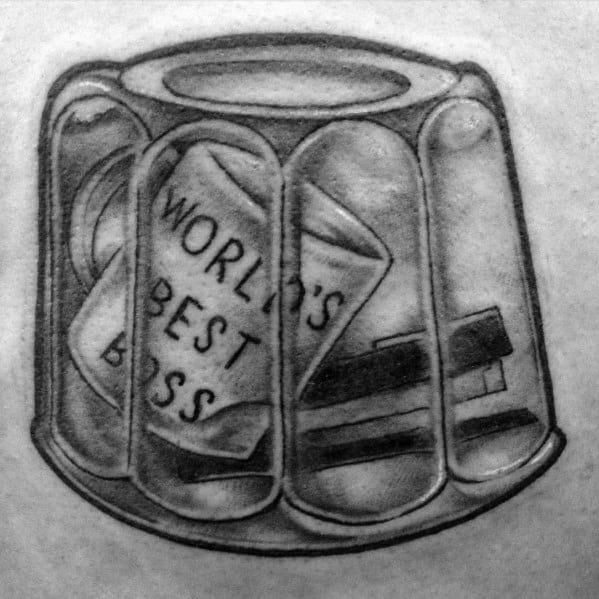 Black and white tattoo of a Jell-O mold containing Michael Scott's "World’s Best Boss" mug and a stapler, referencing The Office prank.