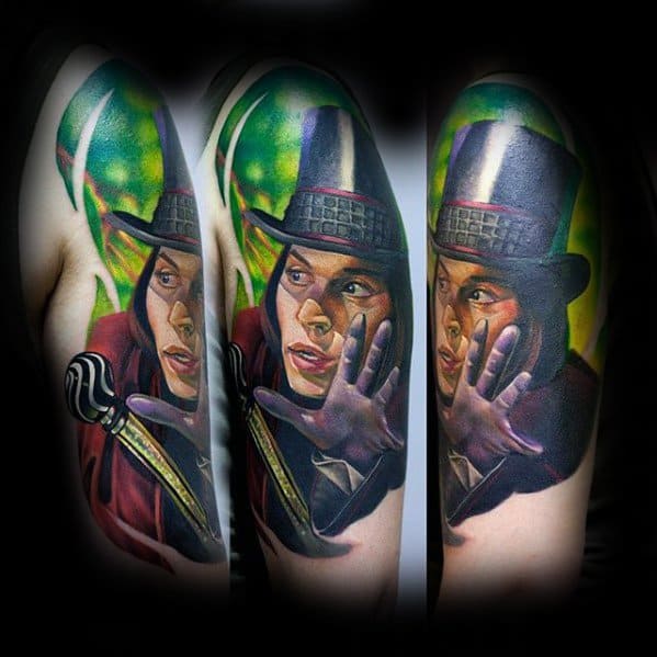 Detailed tattoo of Willy Wonka with a black top hat, gloves, and cane, set against a vivid green background in a dynamic pose.