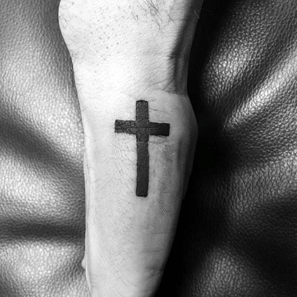 Side hand tattoo for men showcasing a bold black cross design inked vertically along the outer edge of the hand.