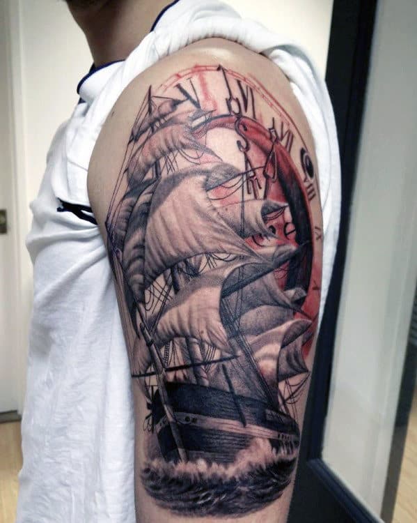A tattoo of a ship and clock on a person's upper arm
