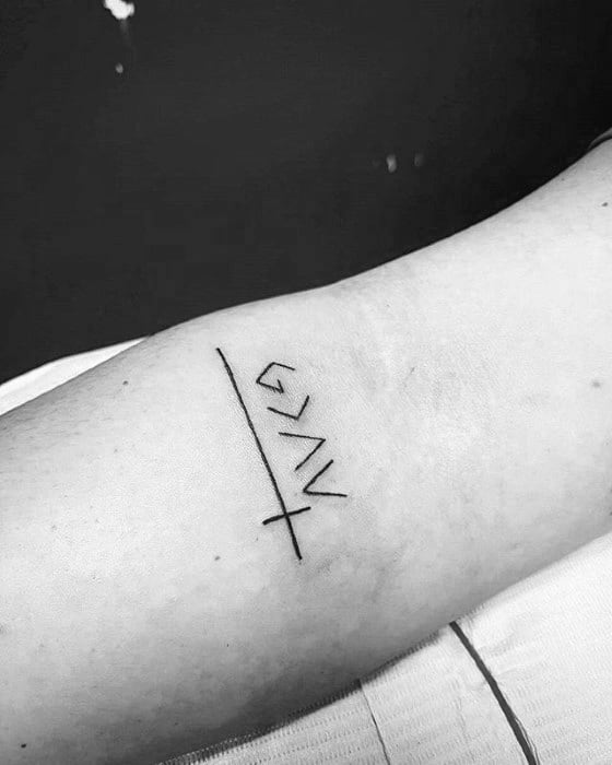 Minimalist tattoo featuring "God is greater than the highs and lows" symbol with a cross and underline detail