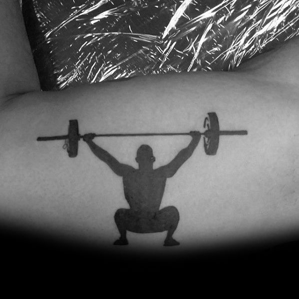 Minimalist black silhouette tattoo of a weightlifter performing an overhead squat, symbolizing strength, power, and dedication to Olympic lifting and CrossFit.