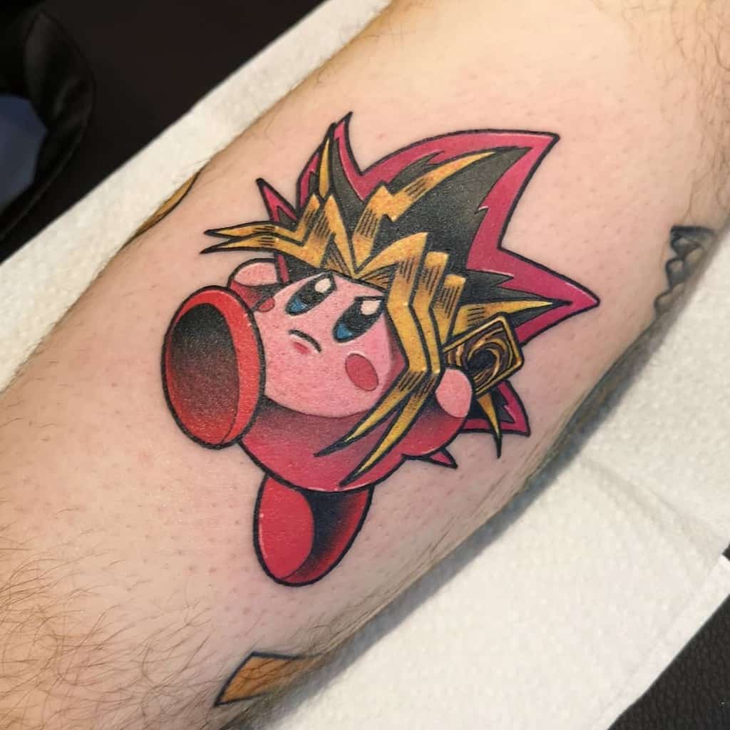 Kirby tattoo styled as Yugi from Yu-Gi-Oh!, with spiky golden hair, holding a yugioh card and a determined look