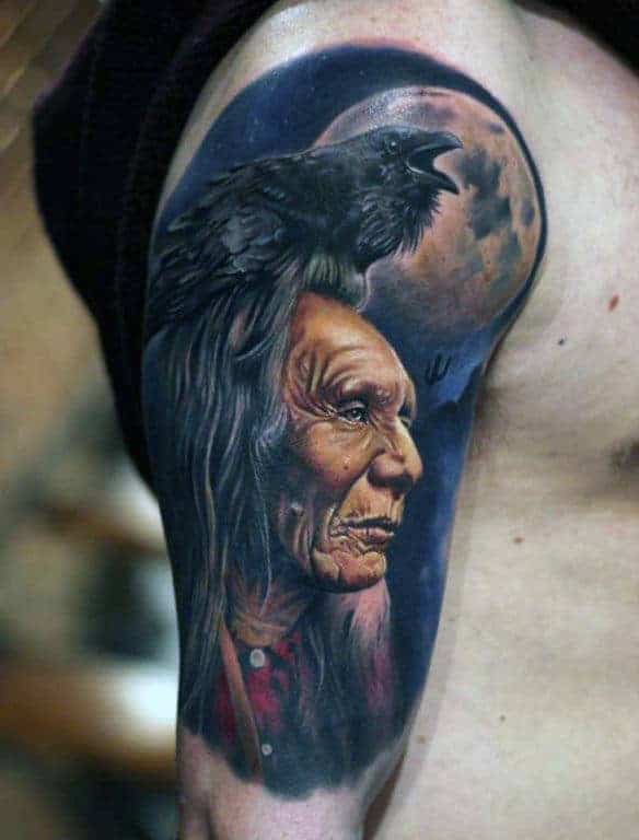 Arm tattoo of an elder with a crow perched on their head under a moonlit sky