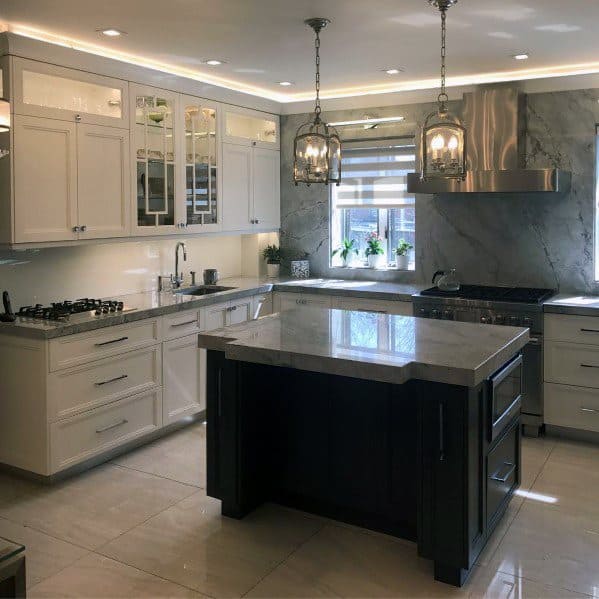 Bright and modern kitchen with crown molding lighting, pendant lights, and sleek marble finishes