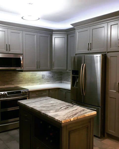 Sleek kitchen with white LED crown molding lighting, modern cabinets, and marble countertops