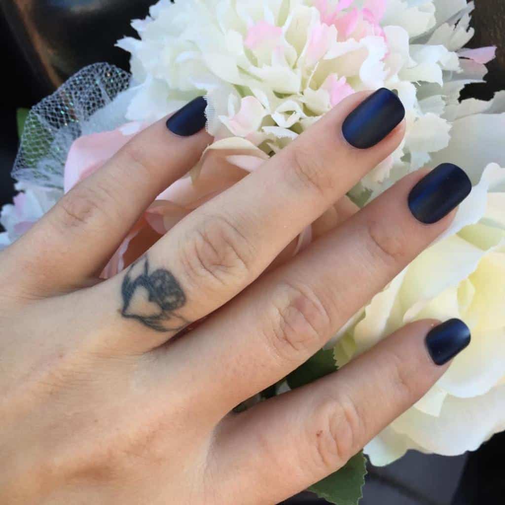 A wedding ring tattoo of a heart with a crown while two hands holding the heart, symbolizing love