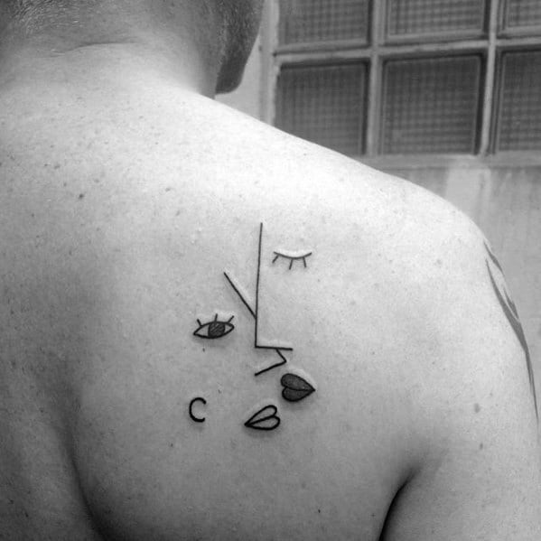Minimalist Cubist tattoo on the upper back showing an abstract face using simple lines, lips, and eyes in a geometric layout.