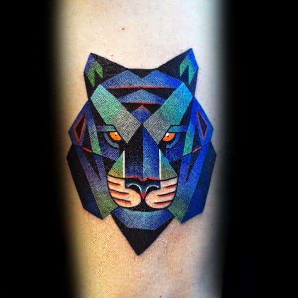 Cubist-style tattoo of a tiger's face with sharp geometric shapes in bold blue, green, and purple tones and intense orange eyes.