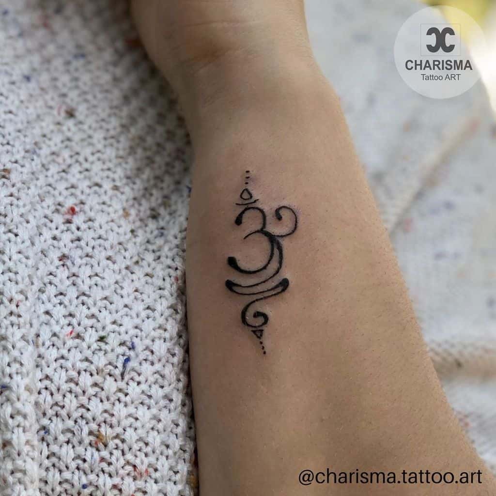 A small Om symbol tattoo graces the forearm, serving as a gentle reminder to breathe deeply and embrace the present moment