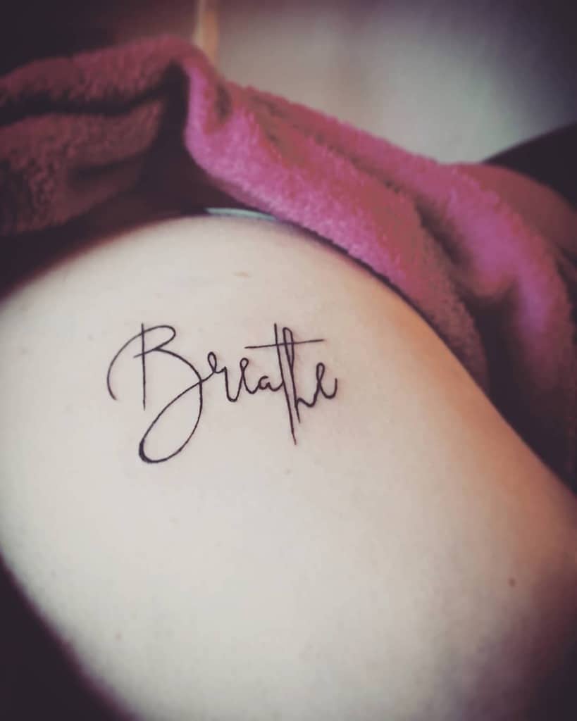 Elegant "Breathe" tattoo in graceful cursive