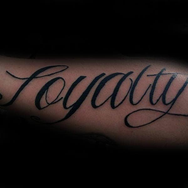 Cursive Loyalty Black Ink Tattoo On Males Outer Forearms