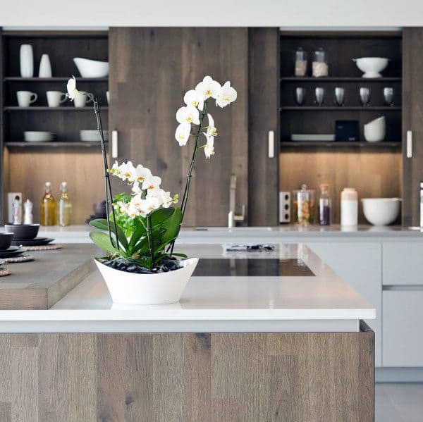 wood kitchen island with marble countertop and white vase with flowers 