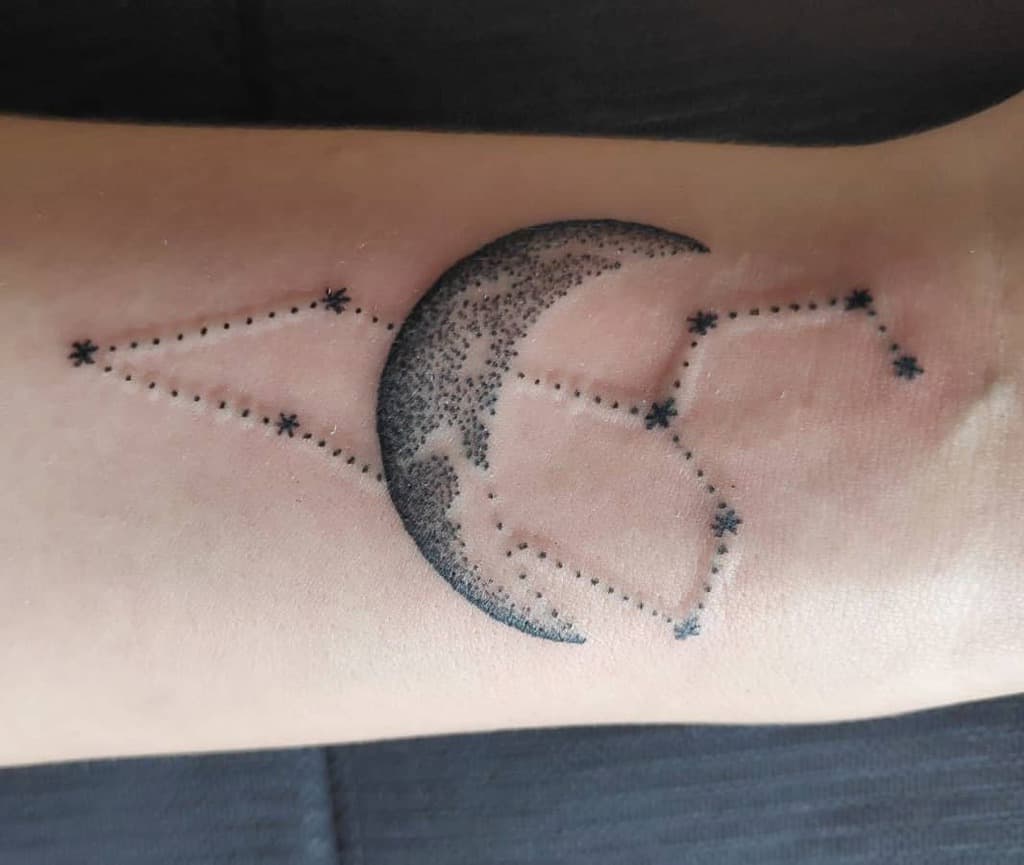 Leo constellation tattoo with a detailed crescent moon, blending astrology and cosmic symbolism in a fine-line design.