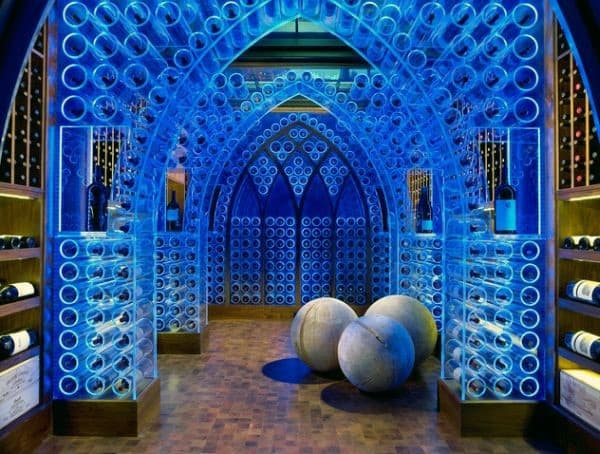 Futuristic wine cellar with blue-lit racks holding wine bottles and two large spherical decorations