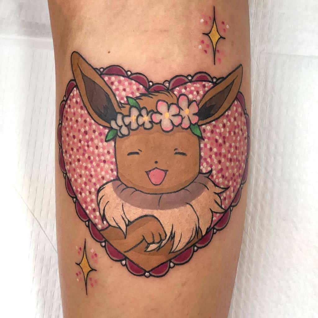 A tattoo of Eevee wearing a flower crown inside a heart, surrounded by sparkles