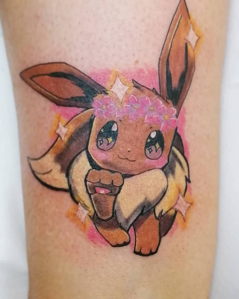 Adorable Eevee tattoo with a pink flower crown and sparkling eyes, set against a bright, playful pink background