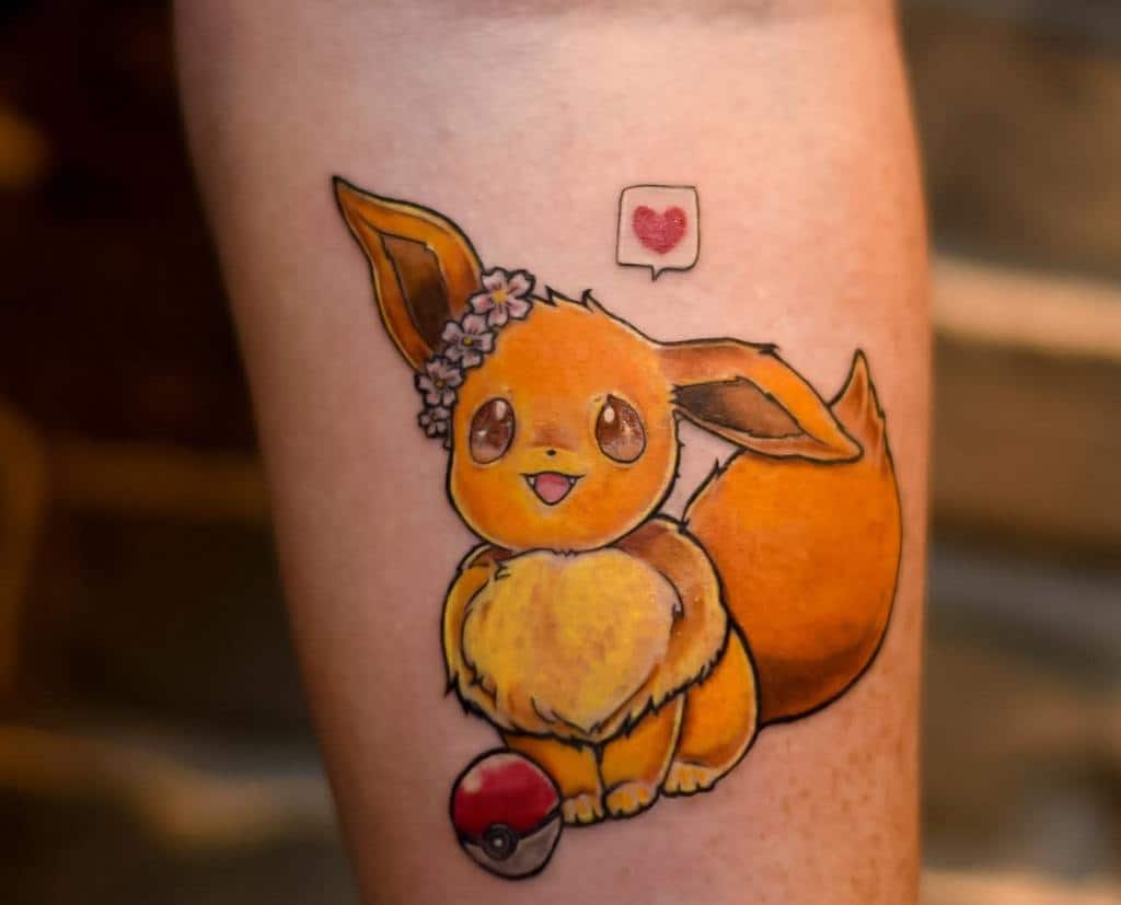Tattoo of a cute, fluffy Eevee with large ears and a floral headband, next to a pokéball and speech bubble heart