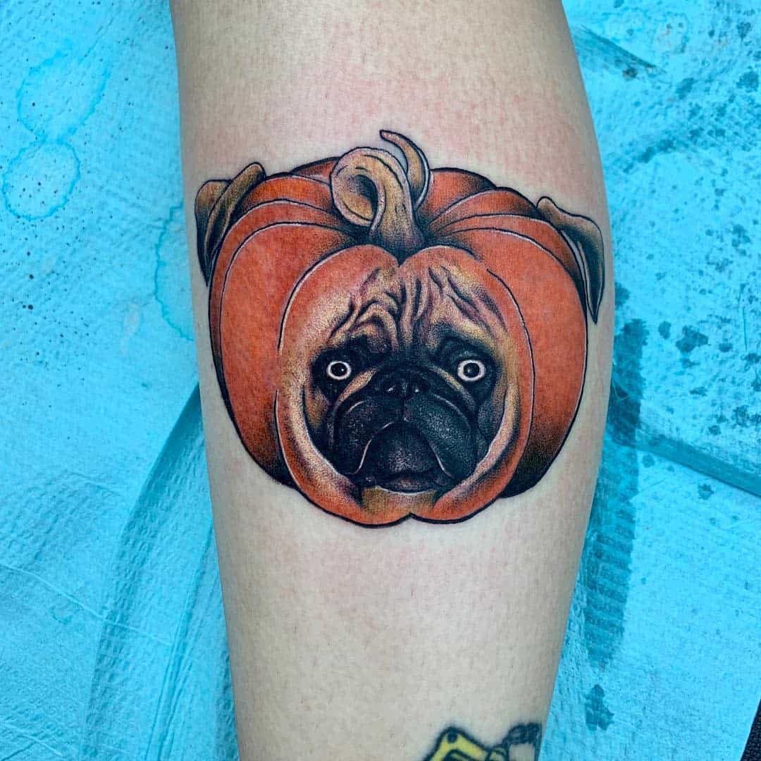 Colorful tattoo of a pug's head inside a pumpkin