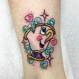 Colorful tattoo of Chip from Beauty and the Beast, surrounded by sparkling bubbles and pink hearts in a playful, vibrant style.