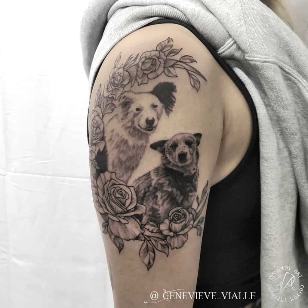 Black and gray tattoo of two dogs with roses and leaves on an upper arm
