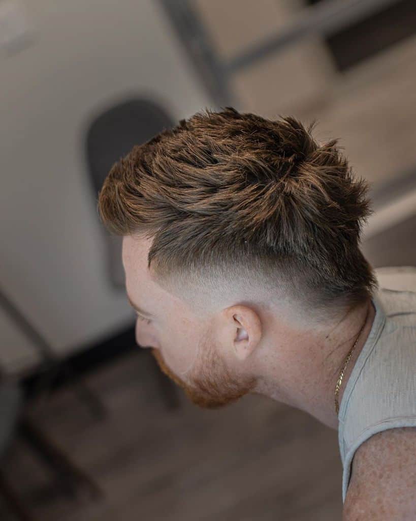 A Mohawk cut with hair extending from front to nape and barely noticeable fading on the sides