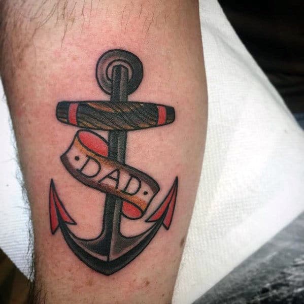 Classic anchor tattoo with a "Dad" banner, bold black outlines, red accents, and shading, symbolizing strength, love, and remembrance.