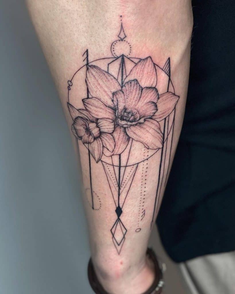 A geometric-style tattoo with daffodils at the center, surrounded by intricate lines and shapes, blending floral and abstract elements.