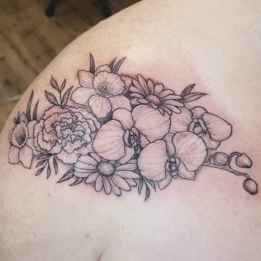A beautifully arranged tattoo featuring a mix of delicate daffodils, orchids, and daisies. The design flows across the shoulder with soft shading and fine lines, creating an intricate and harmonious floral composition.