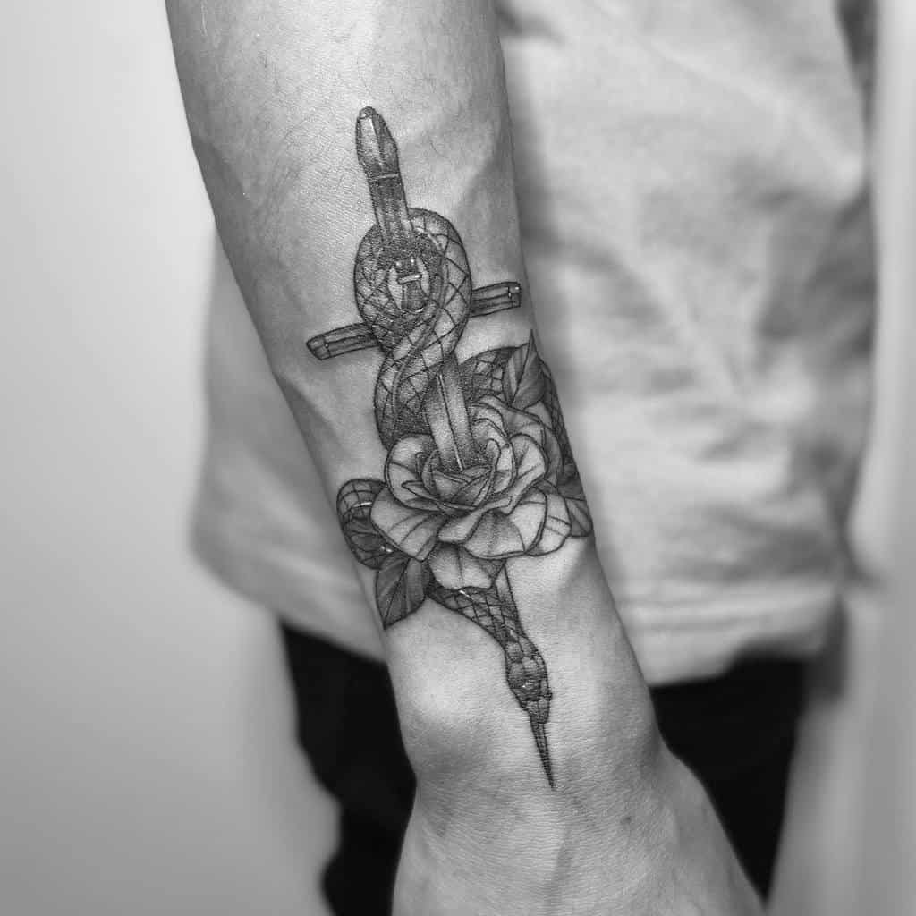 Forearm tattoo of a snake wrapped around a dagger piercing a rose, in black and gray ink