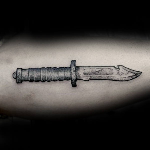 Tattoo of a detailed knife with a textured handle on light skin