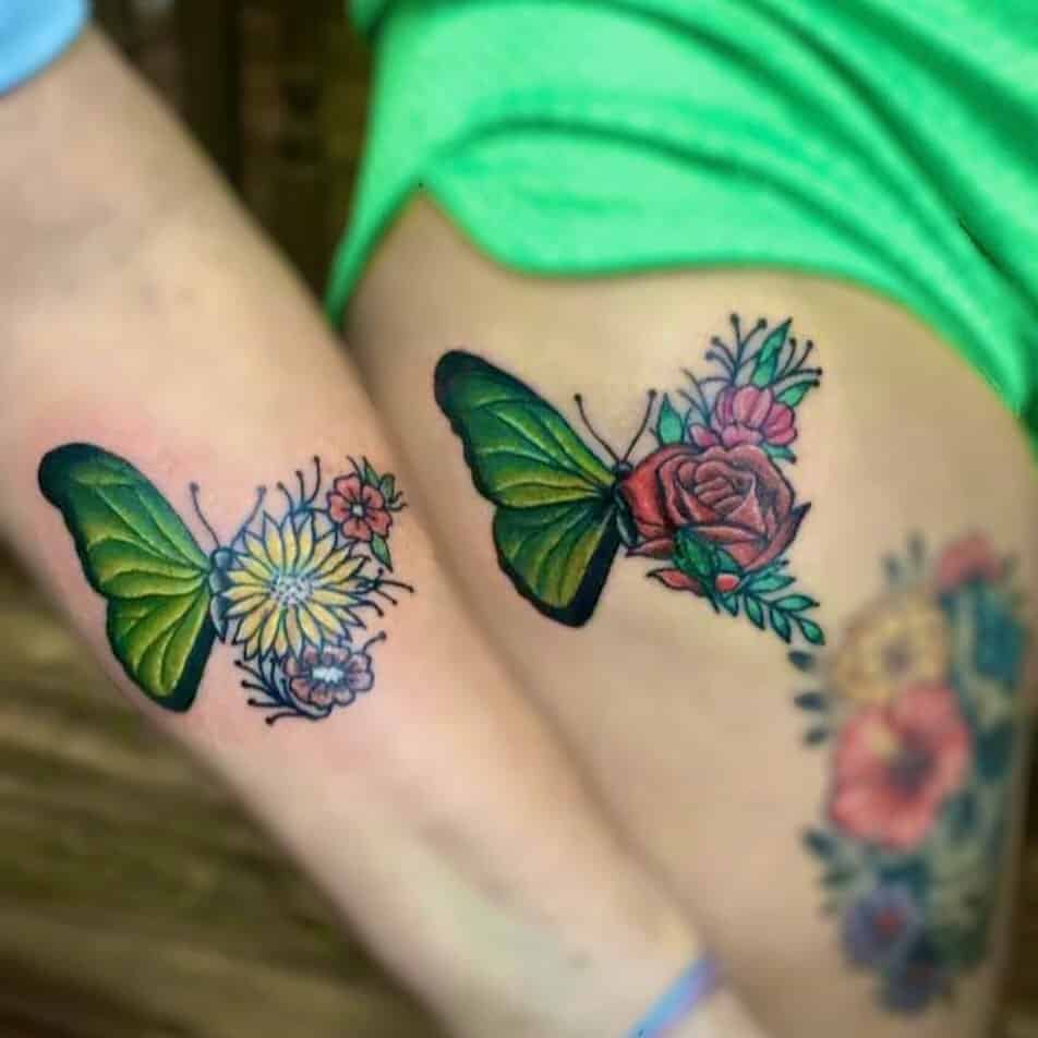 Forearm and thigh tattoos matching color butterflies, daisies and roses