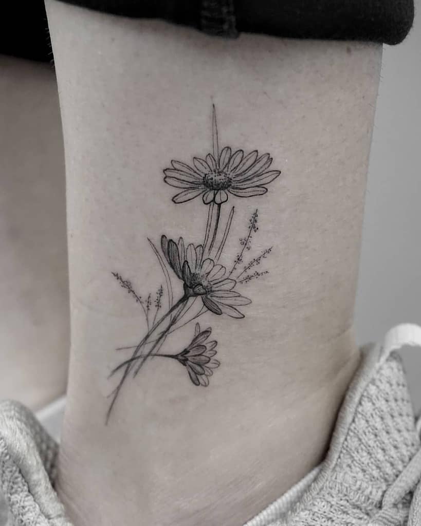 Ankle tattoo black and grey fine line daisy bouquet