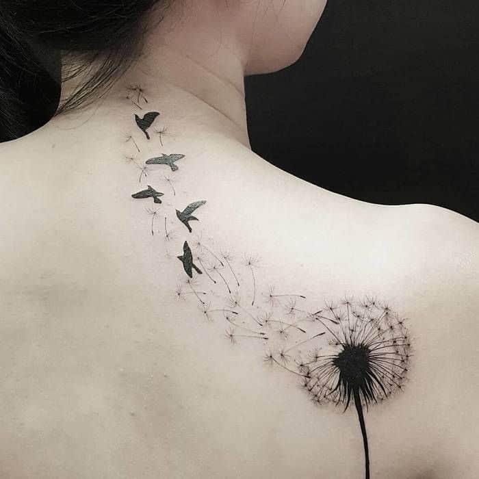 Stunning dandelion tattoo on the shoulder with seeds transforming into birds, symbolizing freedom, transformation, and new beginnings.
