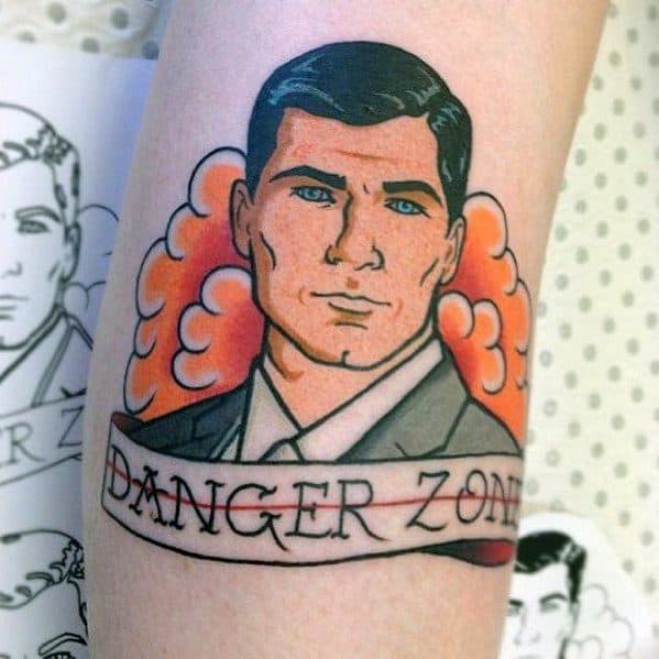 Classic Archer tattoo featuring the suave spy in a suit, framed by orange smoke and a 'Danger Zone' banner in bold lettering.