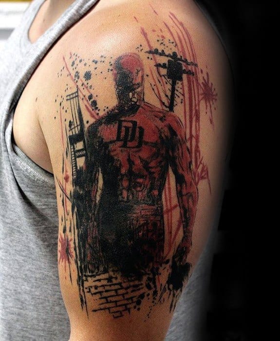 Grunge-style Daredevil tattoo on the upper arm with sketchy black and red ink, bold DD logo, and dynamic urban background elements.
