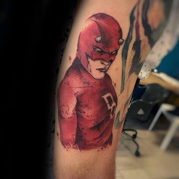 Watercolor-style Daredevil tattoo with sketchy outlines and red ink wash, showcasing a strong pose and expressive comic detail.
