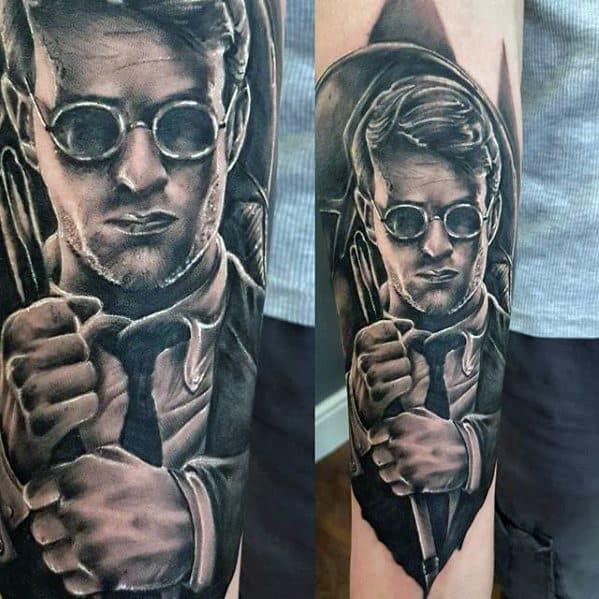 Black and grey tattoo of Matt Murdock in a suit and glasses, holding his cane with a serious, focused expression.
