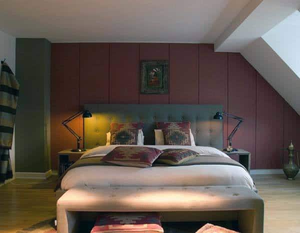 Cozy bedroom with a king-size bed, decorative cushions, red bedside lamps, and warm-toned walls